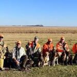 A row of hunters with their bird dogs.