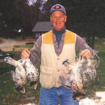 Successful bird hunter holds up impressive number of harvested ruffed grouse.