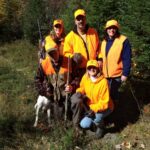 Group of happy bird hunters clad in orange.