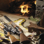 Fireplace in background with guns displayed.