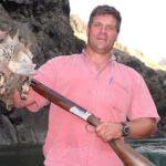 Successful bird hunter holding up harvested chukars. 