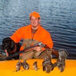 Successful hunter with Labrador retriever with mixed bag of ruffed grouse and woodcock.