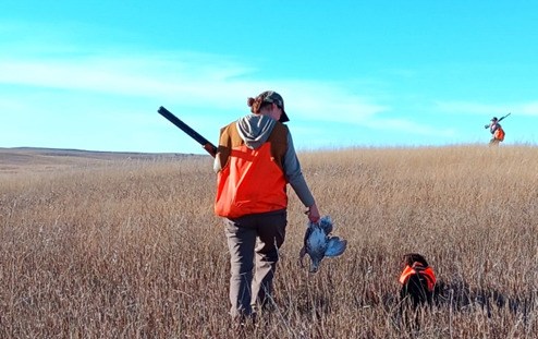 Successful bird hunter afield with dog and husband